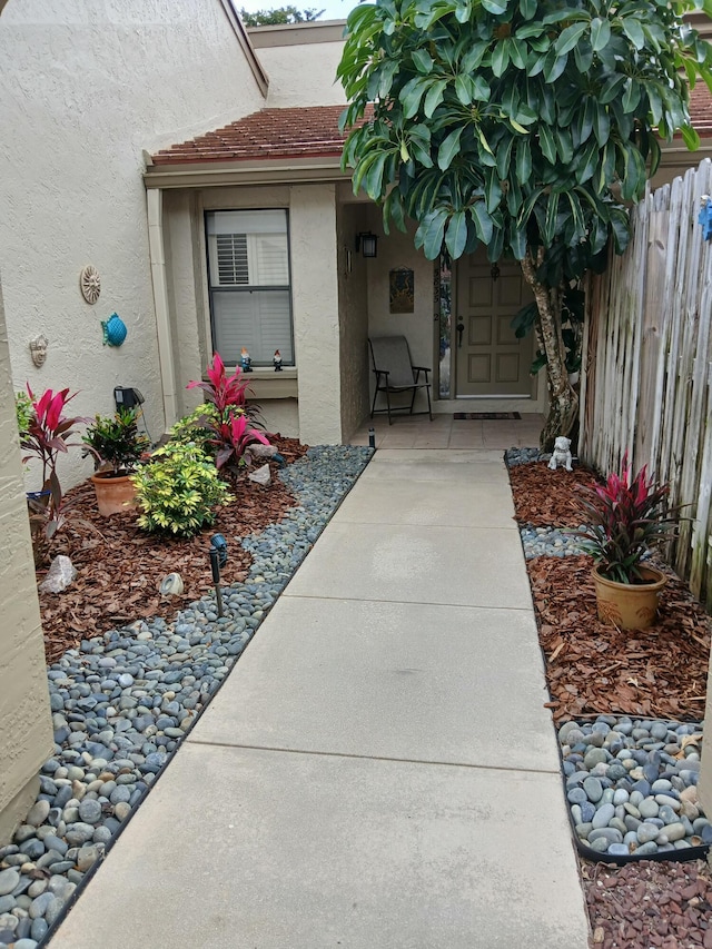 property entrance with fence and stucco siding