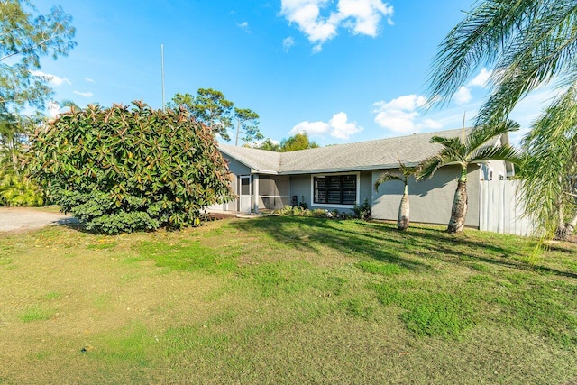 view of front of house with a front lawn, fence, and stucco siding