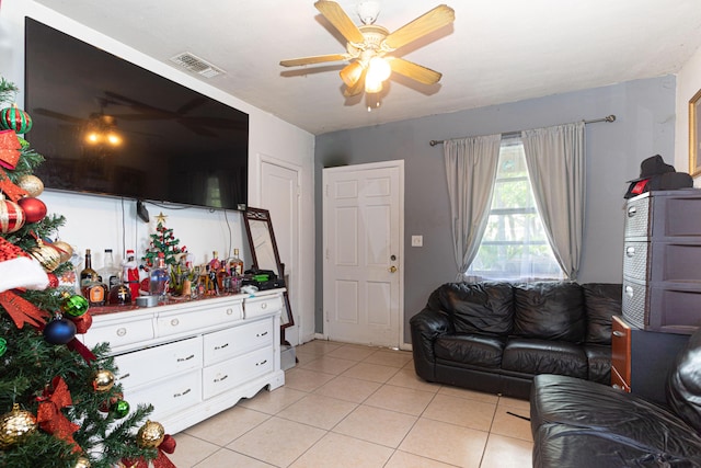 living area featuring a ceiling fan, visible vents, and light tile patterned floors