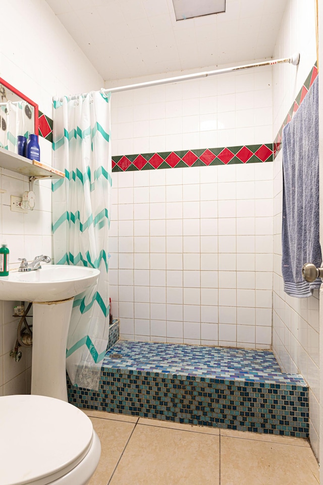 full bath with tile walls, a shower stall, toilet, and tile patterned floors