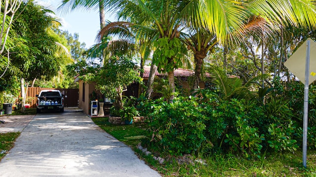 exterior space with concrete driveway, fence, and stucco siding