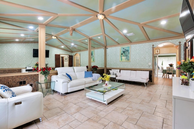 living area with wallpapered walls, visible vents, arched walkways, vaulted ceiling, and crown molding