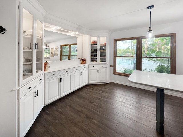 kitchen featuring glass insert cabinets, white cabinetry, light countertops, and pendant lighting