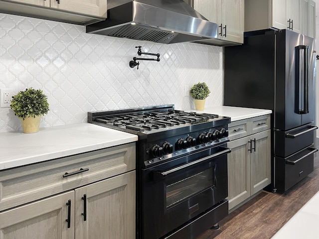 kitchen with premium appliances, dark wood finished floors, ventilation hood, and tasteful backsplash