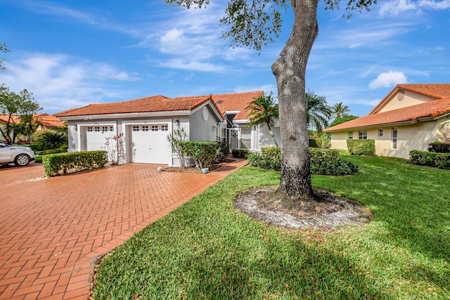 view of front facade with an attached garage, a tiled roof, decorative driveway, stucco siding, and a front lawn