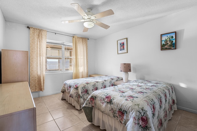 bedroom with ceiling fan, a textured ceiling, and light tile patterned flooring