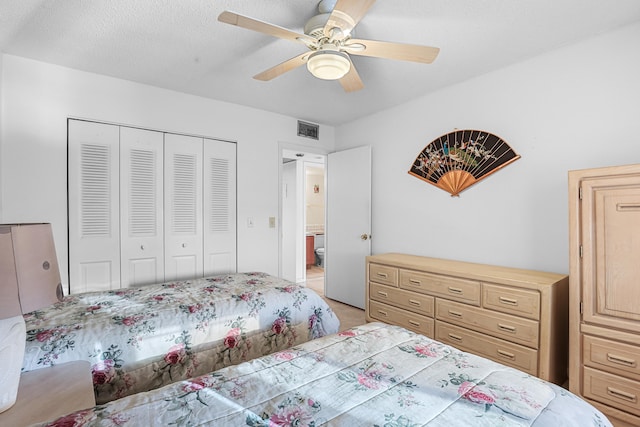 bedroom with a closet, visible vents, ceiling fan, and a textured ceiling