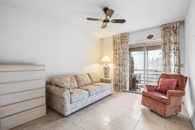 living area with a textured ceiling, ceiling fan, and light tile patterned floors