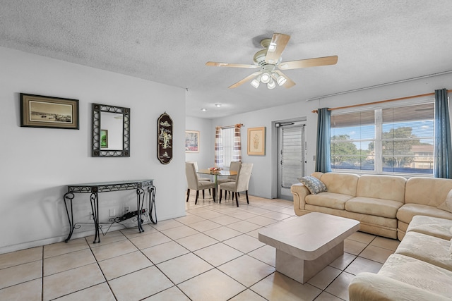 living area featuring ceiling fan, a textured ceiling, and light tile patterned floors