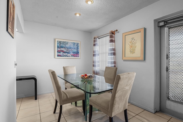 dining area with plenty of natural light, a textured ceiling, and light tile patterned floors