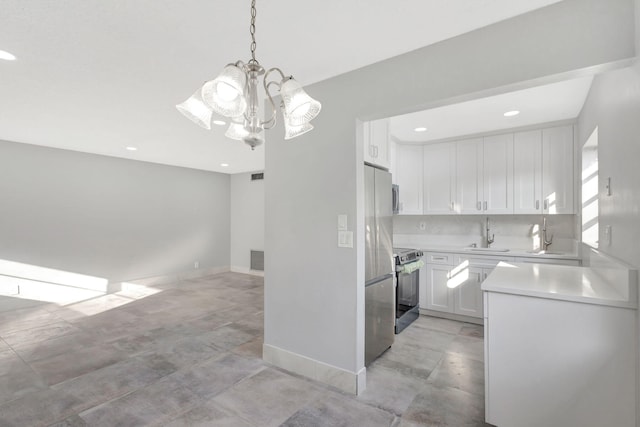 kitchen with tasteful backsplash, white cabinets, stainless steel appliances, light countertops, and a sink