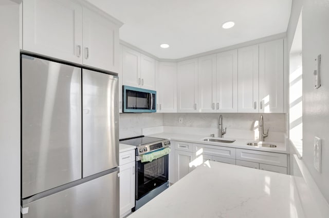 kitchen with stainless steel appliances, recessed lighting, white cabinetry, and a sink