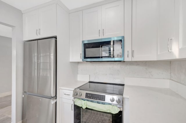 kitchen featuring appliances with stainless steel finishes, white cabinets, and decorative backsplash