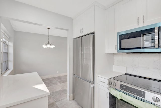 kitchen with appliances with stainless steel finishes, white cabinetry, hanging light fixtures, and decorative backsplash