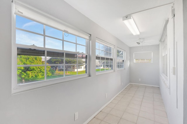 spare room with light tile patterned floors and baseboards