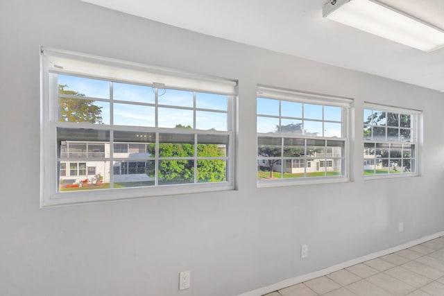 spare room featuring tile patterned flooring and baseboards