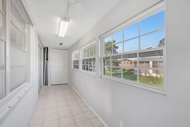 hall with baseboards and light tile patterned floors