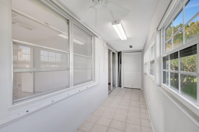 unfurnished sunroom featuring ceiling fan