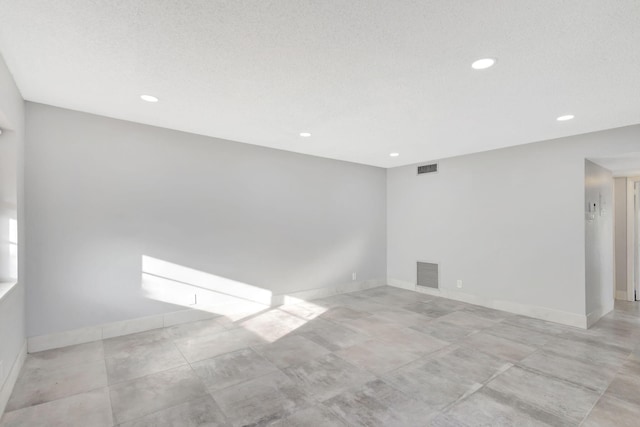 unfurnished room featuring recessed lighting, visible vents, and baseboards