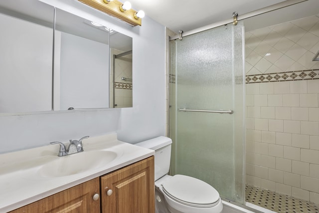 bathroom featuring toilet, a stall shower, and vanity