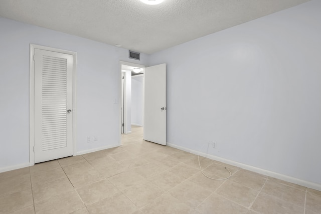 unfurnished bedroom with baseboards, visible vents, and a textured ceiling