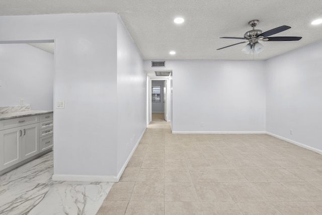 unfurnished room with baseboards, visible vents, a textured ceiling, and recessed lighting