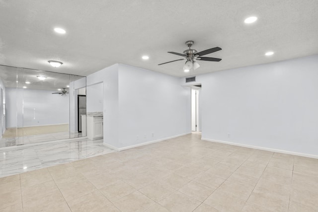 empty room with visible vents, a textured ceiling, a ceiling fan, and recessed lighting