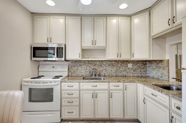 kitchen with stainless steel microwave, a sink, white range with electric stovetop, and decorative backsplash