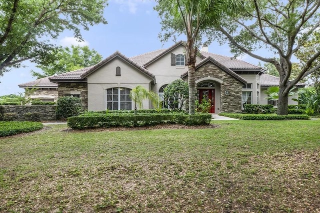 view of front of home featuring stucco siding, stone siding, a chimney, and a front yard