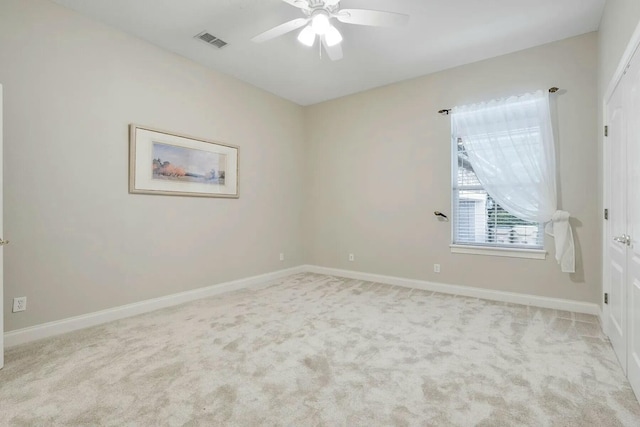 carpeted empty room with visible vents, a ceiling fan, and baseboards