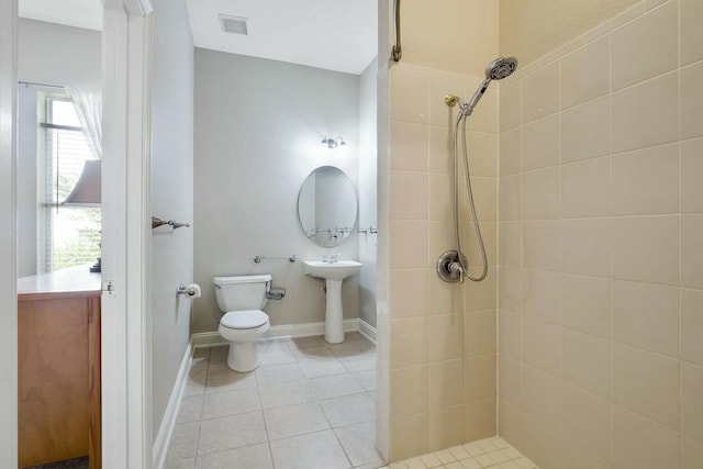 bathroom with tile patterned flooring, toilet, visible vents, and tiled shower