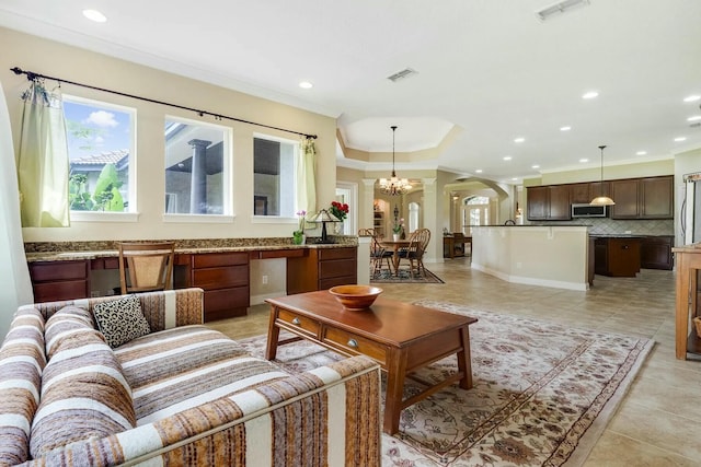 living room featuring light tile patterned flooring, arched walkways, visible vents, and ornamental molding