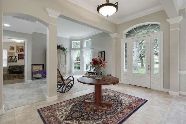 entryway with tile patterned floors, decorative columns, baseboards, and crown molding