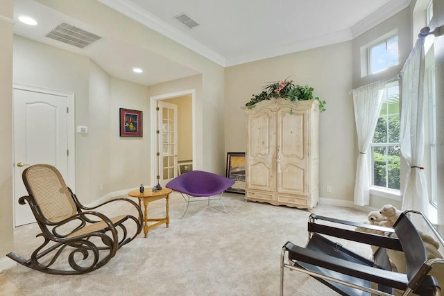 living area with visible vents, light colored carpet, baseboards, and ornamental molding