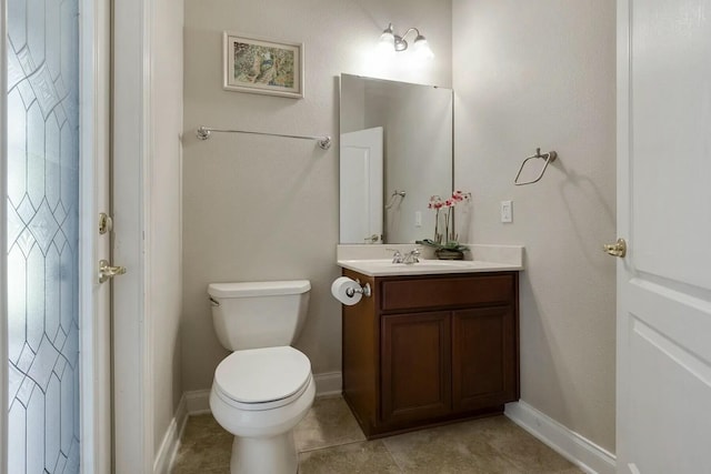 bathroom featuring tile patterned floors, baseboards, toilet, and vanity