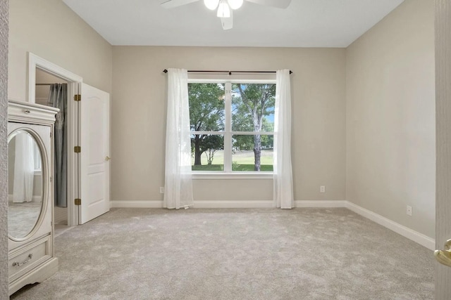 carpeted empty room with baseboards and ceiling fan