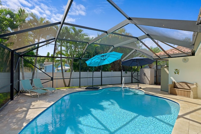 view of swimming pool with a fenced in pool, a lanai, a fenced backyard, and a storage unit