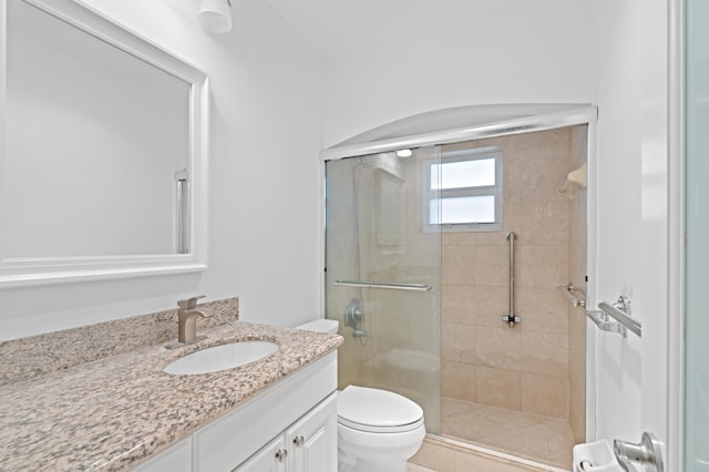 full bathroom with a stall shower, vanity, and toilet