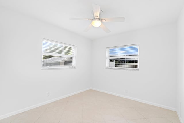 empty room featuring ceiling fan and baseboards