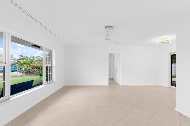 unfurnished room featuring light tile patterned floors, ceiling fan, visible vents, and baseboards