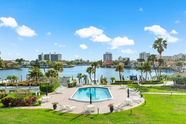 pool featuring a water view, a lawn, and a city view