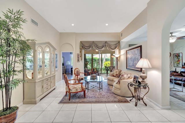 living area with arched walkways, light tile patterned floors, recessed lighting, visible vents, and baseboards