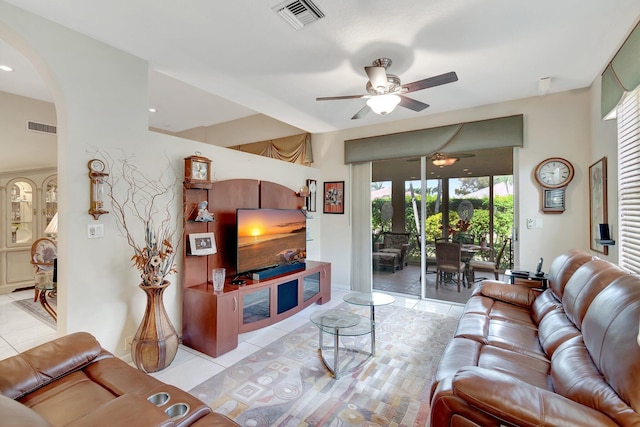 living area featuring a ceiling fan, arched walkways, visible vents, and light tile patterned floors