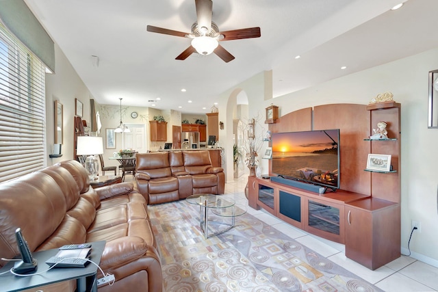 living area featuring arched walkways, light tile patterned floors, recessed lighting, ceiling fan, and baseboards