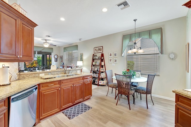 kitchen featuring visible vents, backsplash, a peninsula, stainless steel dishwasher, and a sink