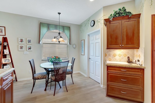 dining area featuring light wood finished floors and baseboards