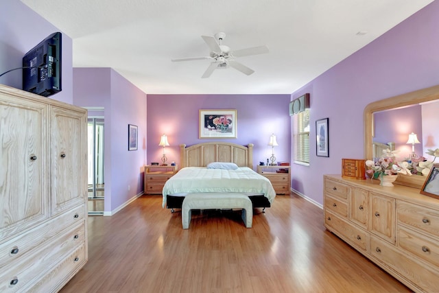 bedroom with light wood finished floors, baseboards, and a ceiling fan