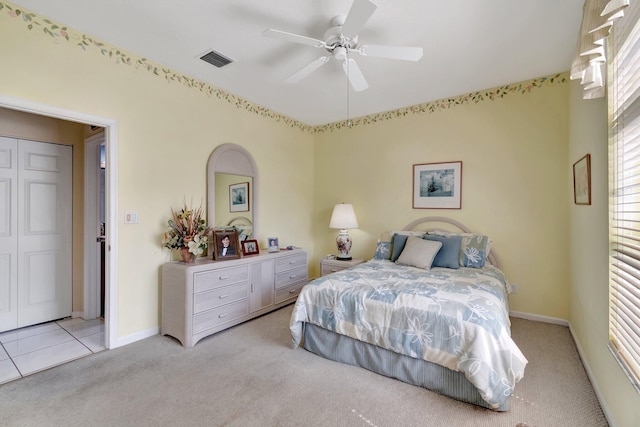 bedroom with baseboards, a ceiling fan, visible vents, and light colored carpet