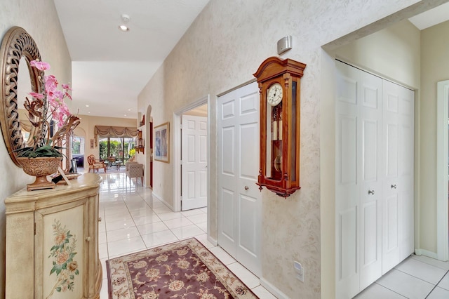 corridor featuring recessed lighting, baseboards, and light tile patterned floors