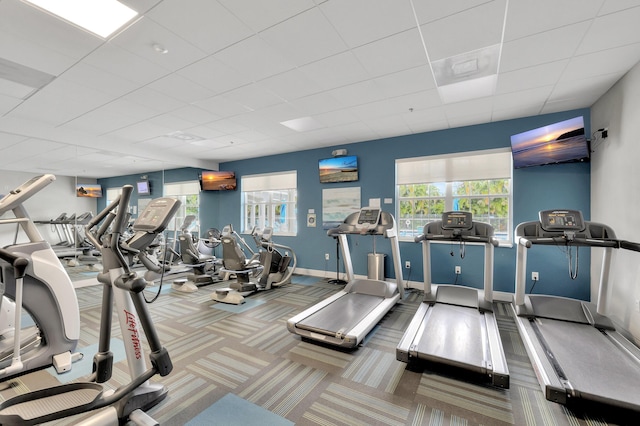 exercise room with carpet flooring, a drop ceiling, and baseboards